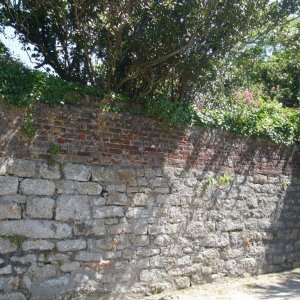 Line of brick in churchyard wall