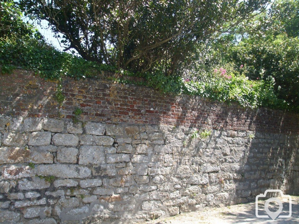 Line of brick in churchyard wall