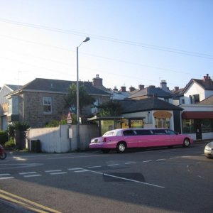 A pink limo by the bus stop