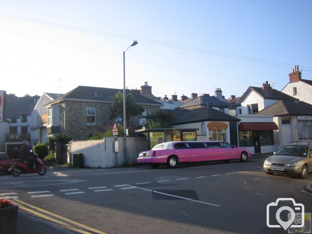 A pink limo by the bus stop