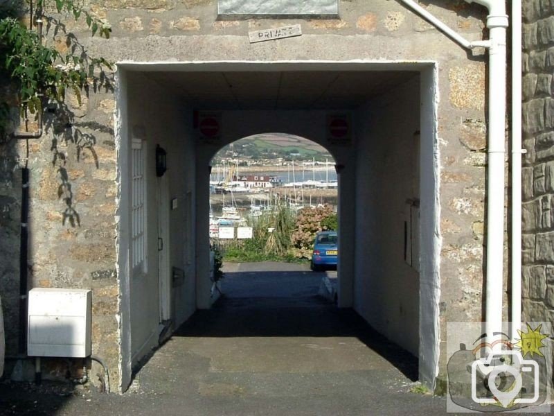 A view of the harbour through an arch in Chapel Street, site of the old Pen