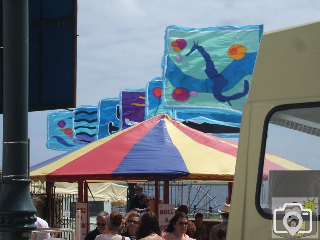 Flags on the Jubilee pool and Quay Fair stall